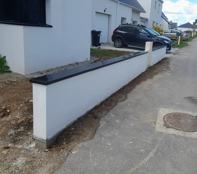 mur de clôture enduit en blanc avec une couvertine à Pluneret